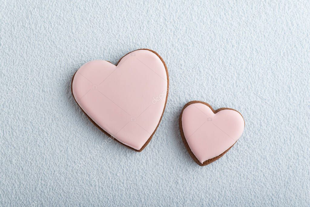 Large and small heart-shaped cookies with icing sugar on white background. Mothers day. Womans day. Valentines day.