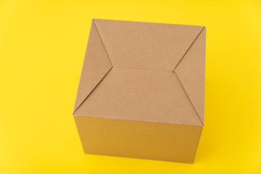 Sarı arka planda karton kutu. El işi ambalajı. Paketin arkası.