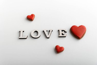 Yazıt, beyaz arka planda farklı boyutlarda aşk ve kırmızı kalpler.