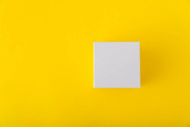 Sarı arka planda beyaz karton kutu. Uzayı kopyala Model