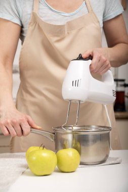 Aşçı elmalı turta hazırlar. Karıştırıcı malzemeleri tencereyle karıştırıyor. Dikey çerçeve.