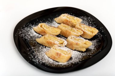 Elmalı çörek, siyah tabakta turta, beyaz arka planda.