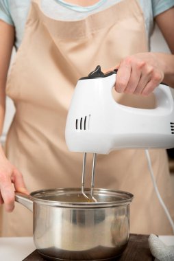 Aşçı hamur hazırlar. Karıştırıcı malzemeleri tencereyle karıştırıyor. Dikey çerçeve.