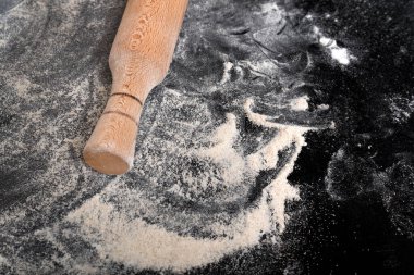 Üzerinde un serpiştirilmiş siyah masa, hamura merdane. Yakın plan..