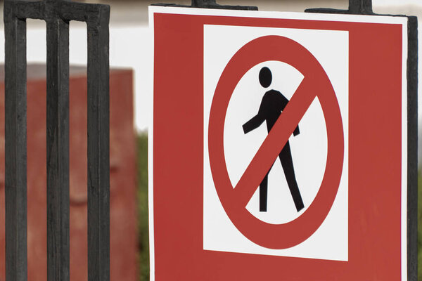Дорожный знак на заборе. Никаких пешеходов. Нет входа.