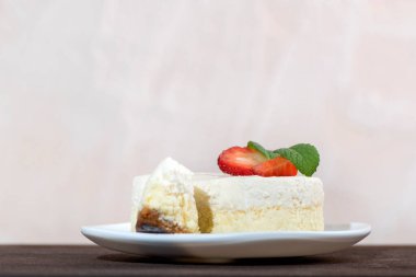 Beyaz tabakta taze çilekli leziz cheesecake. Çocuk oyuncağı. Yan görünüm