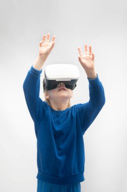 Sanal gerçeklik gözlüklü, elleri havada bir çocuk. VR oyunları. Beyaz arka plan. Dikey çerçeve.