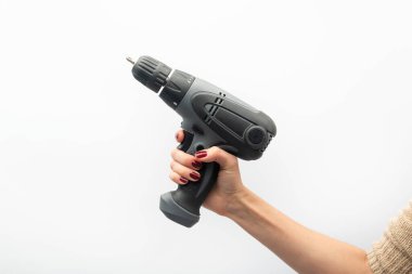 Kadın eli matkabı tutuyor. Beyaz arka planda izole edilmiş. Feminizm kavramı.