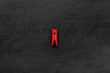 Siyah arka planda kırmızı ahşap mandal. Üst görünüm