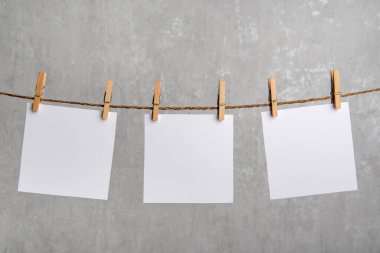 Boş beyaz kağıt notlar halattaki mandallarla sarkıyor. Uzayı kopyala Metnin için yer