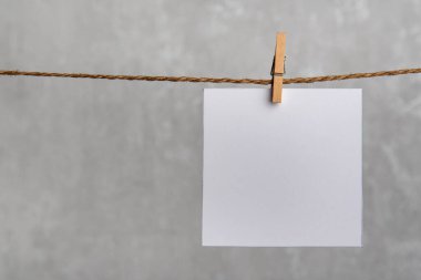 Bir adet boş kare kağıt kart, halat askıskacıyla asılı. Uzayı kopyala, maketle.