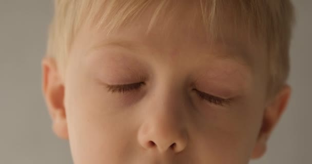 Portrait of a little blond boy opening his eyes. Close-up — Stock Video