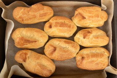 Profiterol, puf, börek, ekin. Taze pişmiş yiyecekler, tepsi görünümünde.