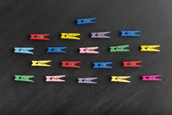 Diverse Bugie Multicolore Clothespins Sono Una Direzione Sfondo Nero Diversità — Foto Stock