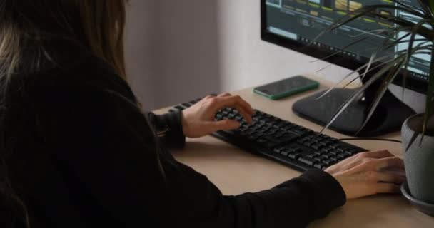 Νεαρή γυναίκα δουλεύει στον υπολογιστή για ένα αργό. Ελεύθερος επαγγελματίας, δούλεψε από το σπίτι. οπίσθια όψη. — Αρχείο Βίντεο