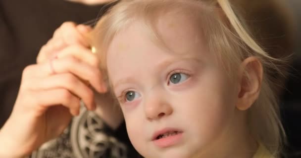 Moher peinando el pelo de la niña rubia. De cerca. Retrato — Vídeos de Stock