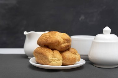 Gri arka planda ev yapımı profiteroller. Puf, puf, börek. Geleneksel Fransız ekleriName.