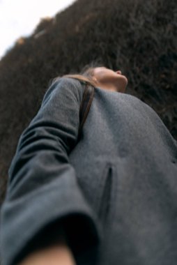 Kız poposunun portresi. Genç bayan yukarı bak. Kız dışarı çıkıyor. Arka plandaki eski duvar.