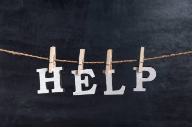 Kara arka planda mandallarla Kelime Yardımı. Beyaz harflerle yazılmış..