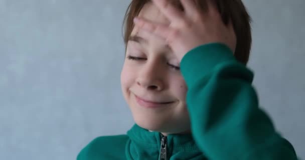Adolescente bonito remove o cabelo do rosto. Retrato de um menino de escola feliz em casa — Vídeo de Stock