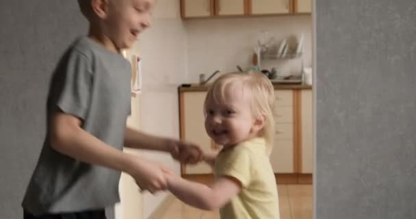 Blonde happy children jump and spin holding hands. Children have fun at home. Siblings have a joyful time — Vídeo de Stock