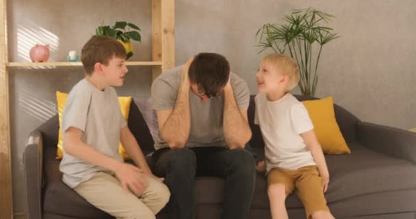 Father put his hands around his head, the children are fighting and arguing. Parent is tired of noisy children. Family conflict — Stock Video