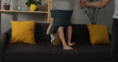 Erkek eli yumrukla tehdit eder, çocuk korkuyla yastığın arkasına saklanır. Oğlu babasından korkuyor. Aile içi şiddet. Zorla eğitim