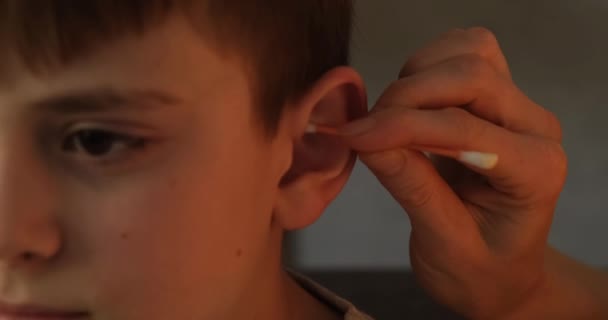 Limpeza das orelhas das crianças em casa close-up. Procedimentos de higiene. Luz natural do dia — Vídeo de Stock