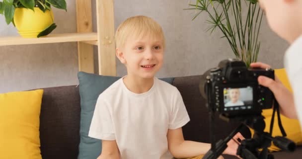 Dos jóvenes hacen contenido para video blog en la cámara en casa en el sofá. Creatividad infantil en Internet — Vídeos de Stock