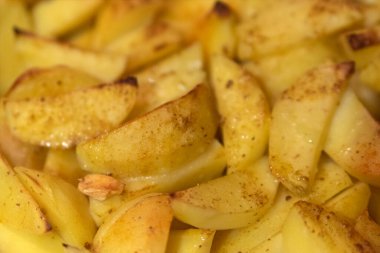 Parçalara ayrılmış taze baharatlı patatesler. Vejetaryen yemeği. Kızarmış patates dilimleri, yakın çekim. Patates yemeği.
