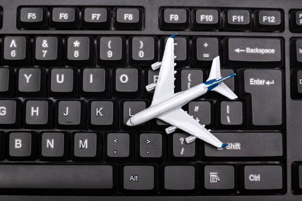 Model of the airplane on a computer keyboard. Buying air tickets online