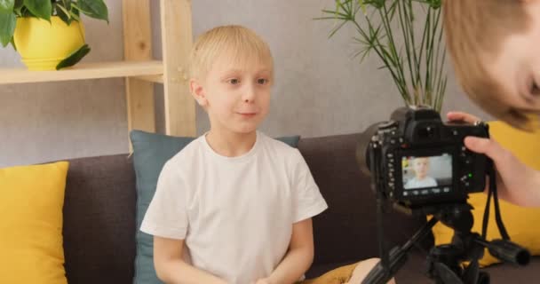 Dos jóvenes hacen contenido para video blog en la cámara en casa en el sofá. Creatividad infantil en Internet — Vídeos de Stock