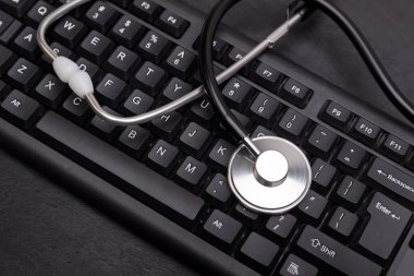 Stetoskop ve bilgisayar klavyesi. Bilgisayar anti-virüs koruma ve hizmet. Çevrimiçi tedavi.