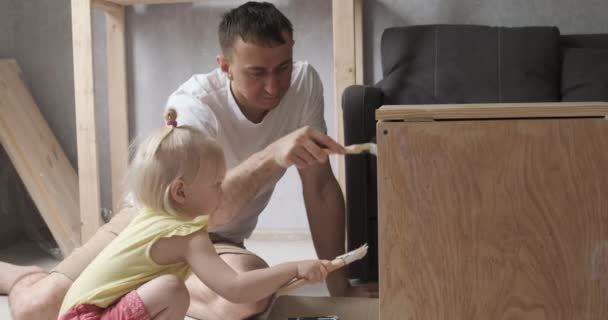 Baba ve küçük kız marangozluk yapıyorlar. Marangozluk atölyesinde kızı babasına yardım ediyor.. — Stok video