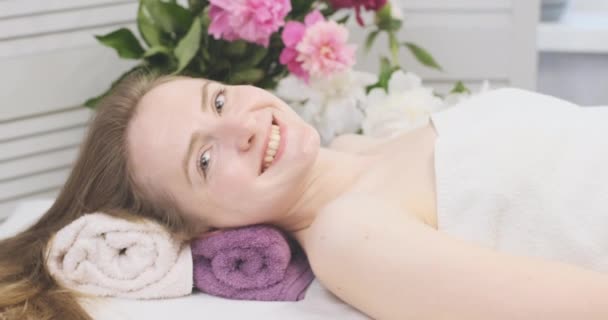 Vacker flicka ligger i spa salong och leenden. Kvinnor som får kosmetiska behandlingar. — Stockvideo