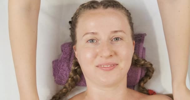 Mujer joven acostada en la cama de spa y recibiendo tratamiento de spa. Cuidado de la piel profesional. Vista superior. — Vídeos de Stock