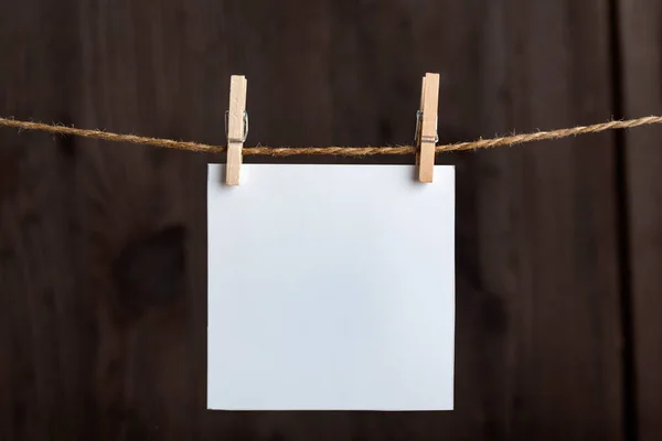 白色空白的字条 用绳子上的衣针挂在木制背景上 复制空间 为您的文字留出空间 — 图库照片