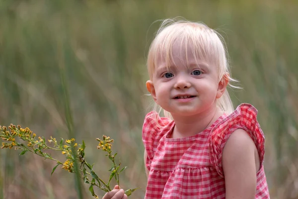 穿着太阳衣的金发美女的画像 带着野花在战场上快乐的孩子 — 图库照片