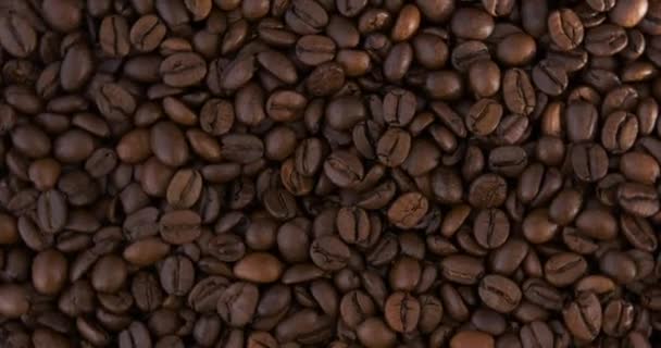 Café arabica torréfié en gros plan. Grains de café noir. Vue de dessus. Vidéo tournante. Mouvement de boucle. — Video