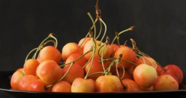 Tabakta olgun, sulu sarı kirazlar. Yan görüş. Saat yönünde dön. Döngü hareketi. 