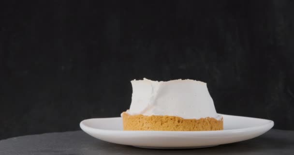 Tortenkuchen mit Sahne auf Teller auf schwarzem Hintergrund. Hausgemachtes Dessert. Rotierendes Video. — Stockvideo