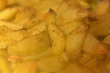 Sliced potatoes during cooking. Baked potatoes. Process of cooking baked potatoes. Close up