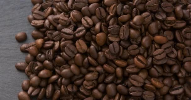 짙은 커피나무. 볶은 커피 원두가 돌고 있습니다. 우아 한 아라 비카 와 로 부스타. 회전하는 영상. 느슨 한 움직임. — 비디오