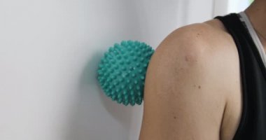 Topla omuz kaslarına masaj yap. Fizyoterapi için paten. Kapatın. Bağ gevşemesi için masaj topu.
