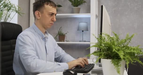 O jovem adormece de fadiga no teclado. Trabalhador de escritório está chateado e não vê ponto no trabalho. — Vídeo de Stock