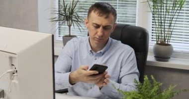 Erkek ofis çalışanı telefonda konuşur ve kağıda veri yazar. Erkek sekreter. Yardımcı Yönetmen.