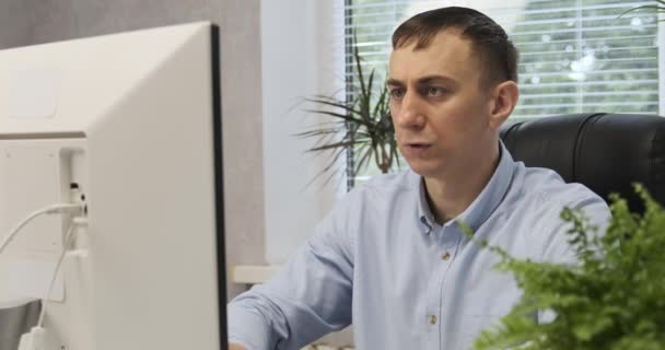 Серйозний керівник середнього віку працює в офісі за комп'ютером. Директор у своєму кріслі . — стокове відео