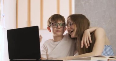 Anne ve oğul bilgisayar aracılığıyla arkadaşlarıyla ya da akrabalarıyla iletişim kuruyor. Aileyle video çağrısı.