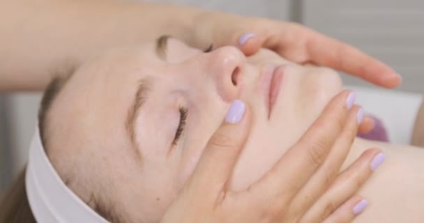 Drenagem linfática modelagem massagem facial. Jovem mulher no salão de spa na sessão de facebuilding. Belas mãos do massagista. Fechar — Vídeo de Stock