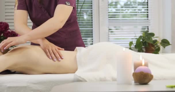 Professionele rugmassage in de spa salon. Vrouwen handen doen een ontspannende massage in een aangename omgeving — Stockvideo